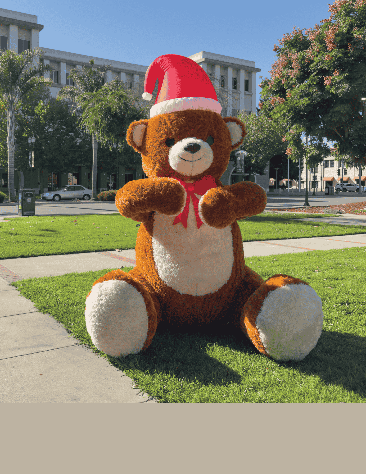 Giant Christmas Teddy Bear Pictured in front of a City Building 
