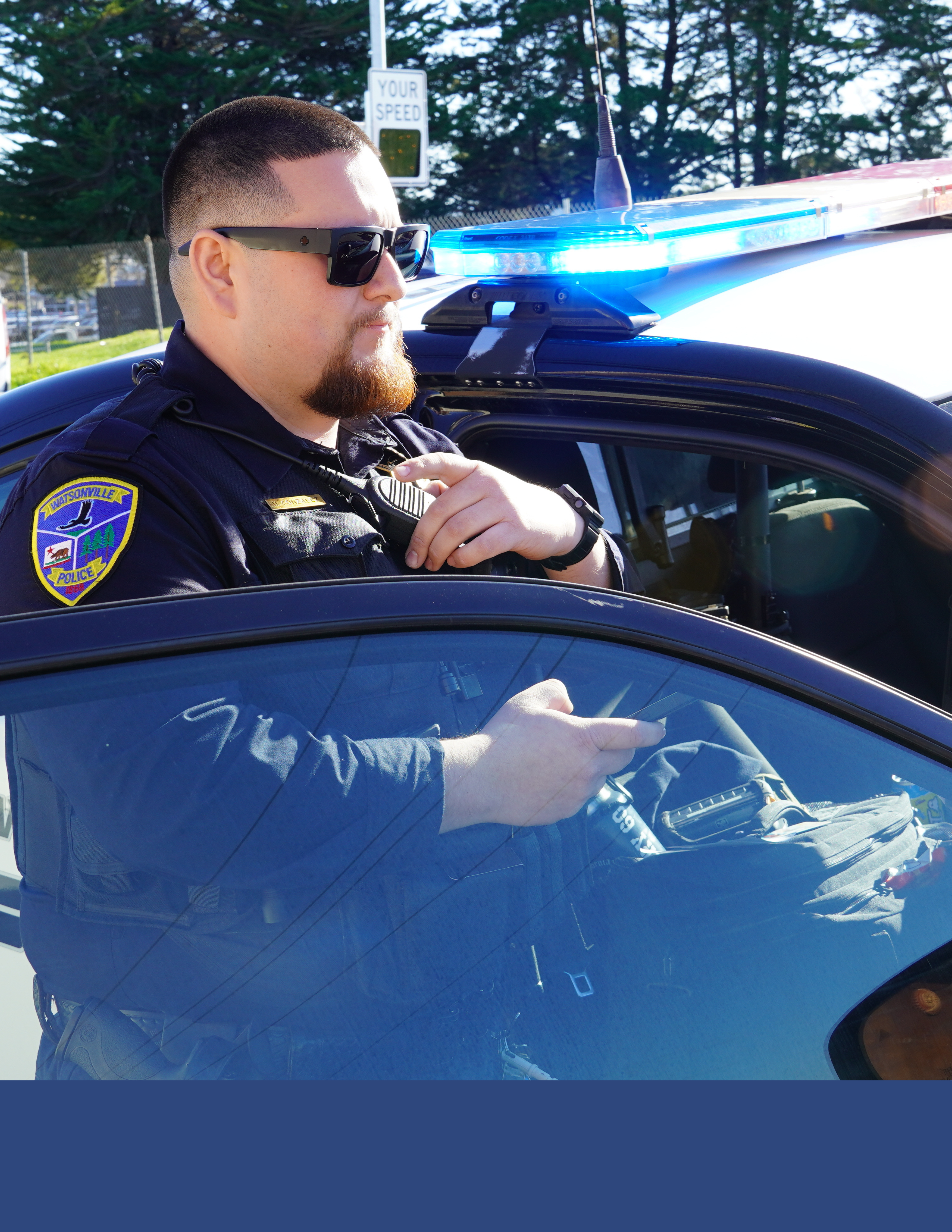 Photo of officer speaking on radio while doing a traffic stop.