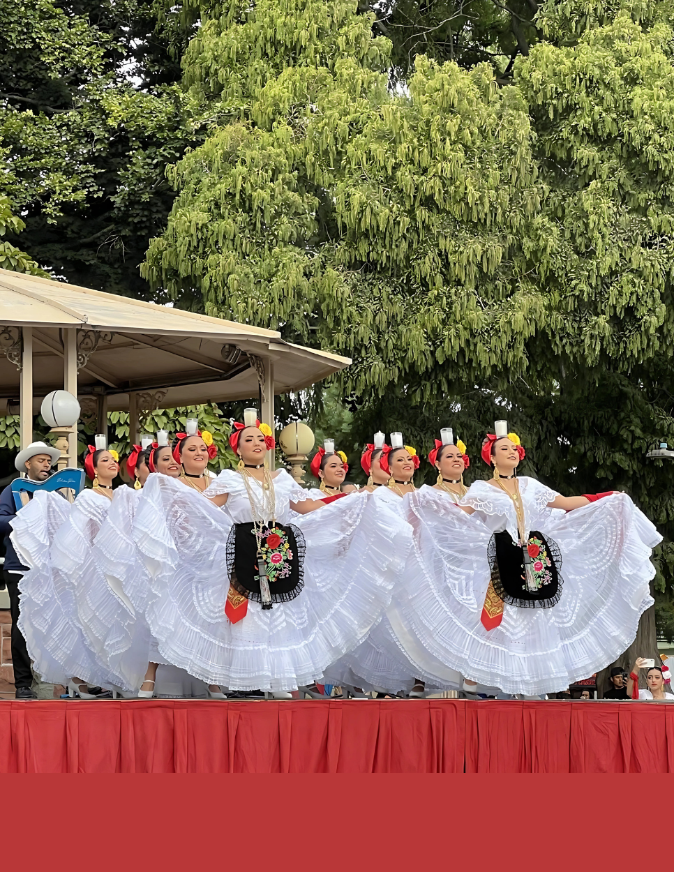 Several Dancers in Mexican Attire Performing in front of an Audience 