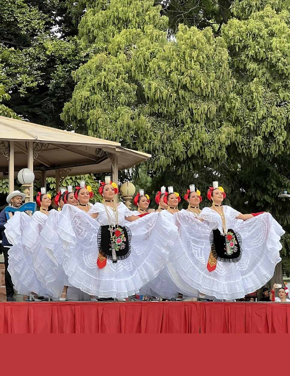 Several Dancers in Mexican Attire Performing in front of an Audience 