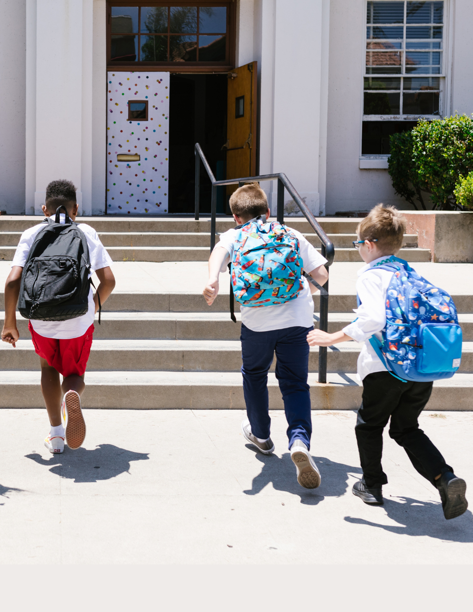 Children on school campus running up school steps 