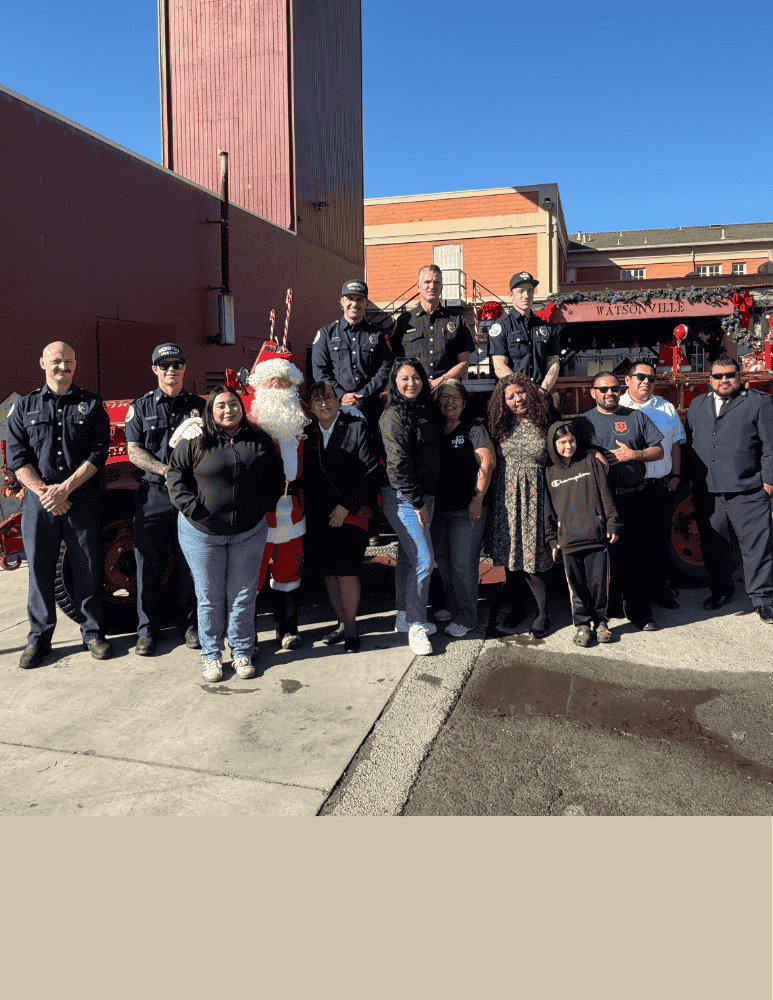 Firefighters, WFD and Salvation Army staff posing for a photo in front of an antique fire truck 